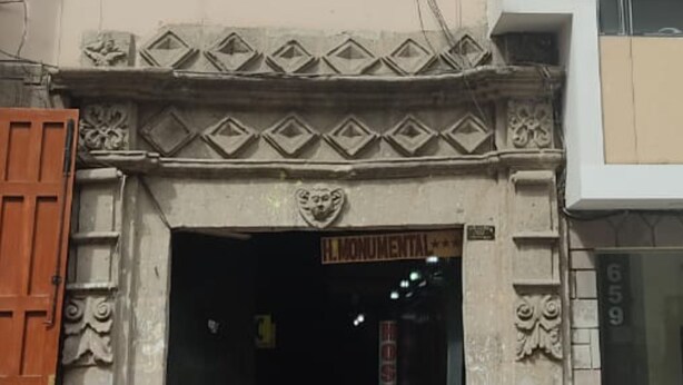 A building entrance with a sign reading "H. Monumental." - Hostal Monumental (Cajamarca)