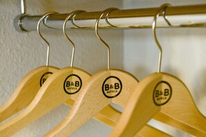 Des cintres en bois portant le logo « B&B HOTELS », suspendus à une tige métallique.