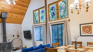 Una sala acogedora con un sofá azul, una mesa de comedor de madera y una chimenea.