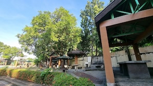 A courtyard with a gazebo, steps leading to a covered area, and a view of a building in the background. - 4k Garden Resort by Cocotel (Santa Maria)