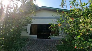 A building with a green roof, a large open doorway, and surrounding greenery. - 4k Garden Resort by Cocotel (Santa Maria)