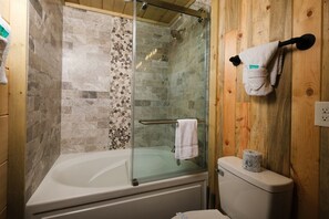 A bathroom with a glass-enclosed shower, a bathtub, and a toilet. - Skyriver Falls - Luxury Indoor Pool, Mini Golf, Firepit, Mountain Views, Hot Tub + Game Room (Sevierville)