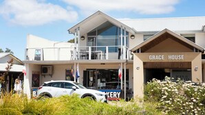 Un bâtiment à deux étages, avec une enseigne indiquant « GRACE HOUSE » et, en dessous, une enseigne de boulangerie.