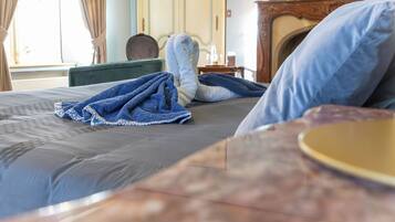 A bed with a blue blanket, a wooden headboard, and a nightstand with a lamp.