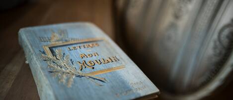 A book titled "Lettre à mon Moulin" with gold lettering and decorative elements, placed on a wooden surface.