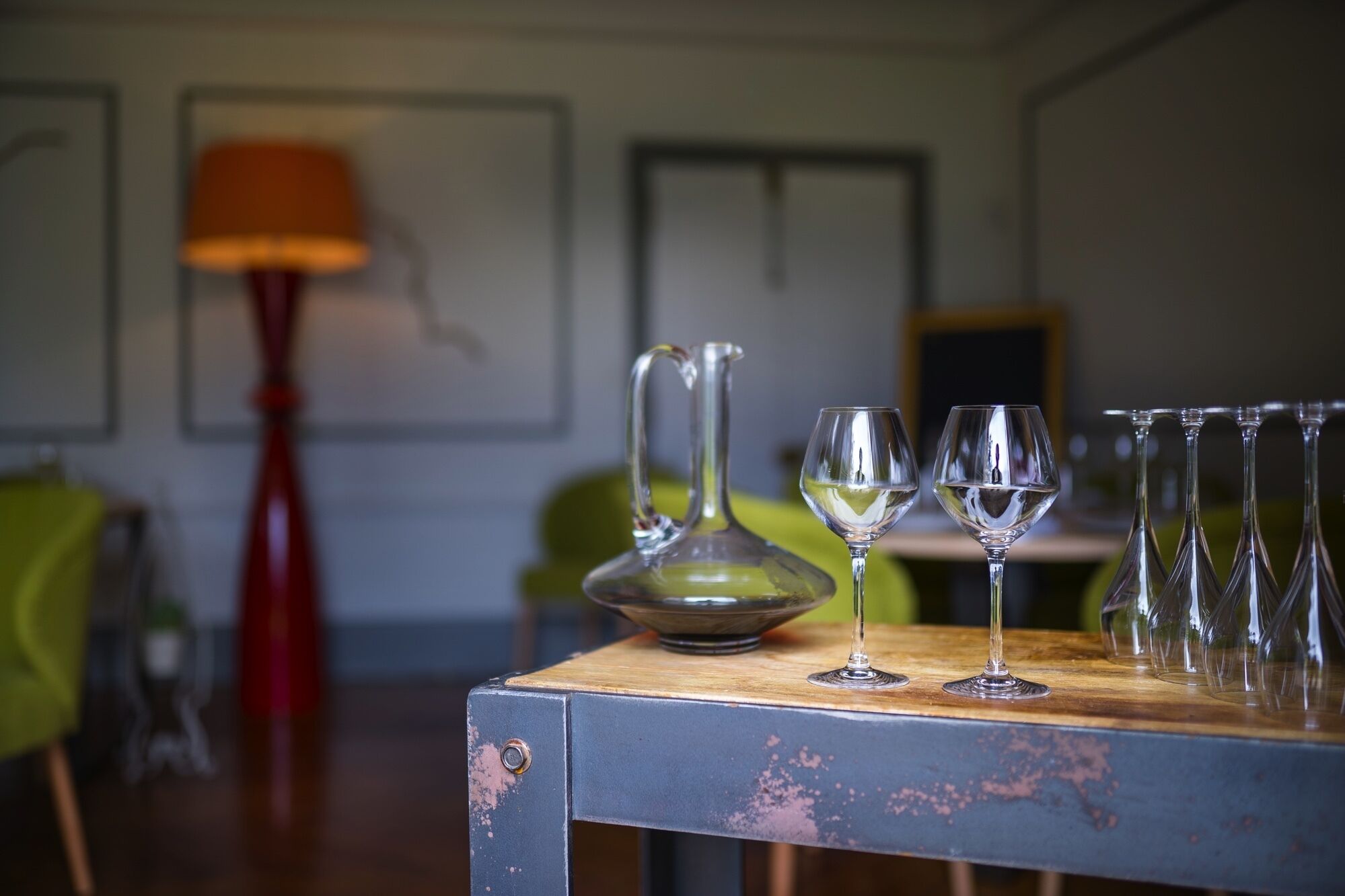 Una mesa con una jarras y varias copas de vino.