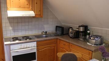 Eine Küche mit Holzausstattung, einem Herd, einer Mikrowelle und einem Toaster.