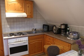 A kitchen with wooden cabinets, a stove, a microwave, and a toaster.