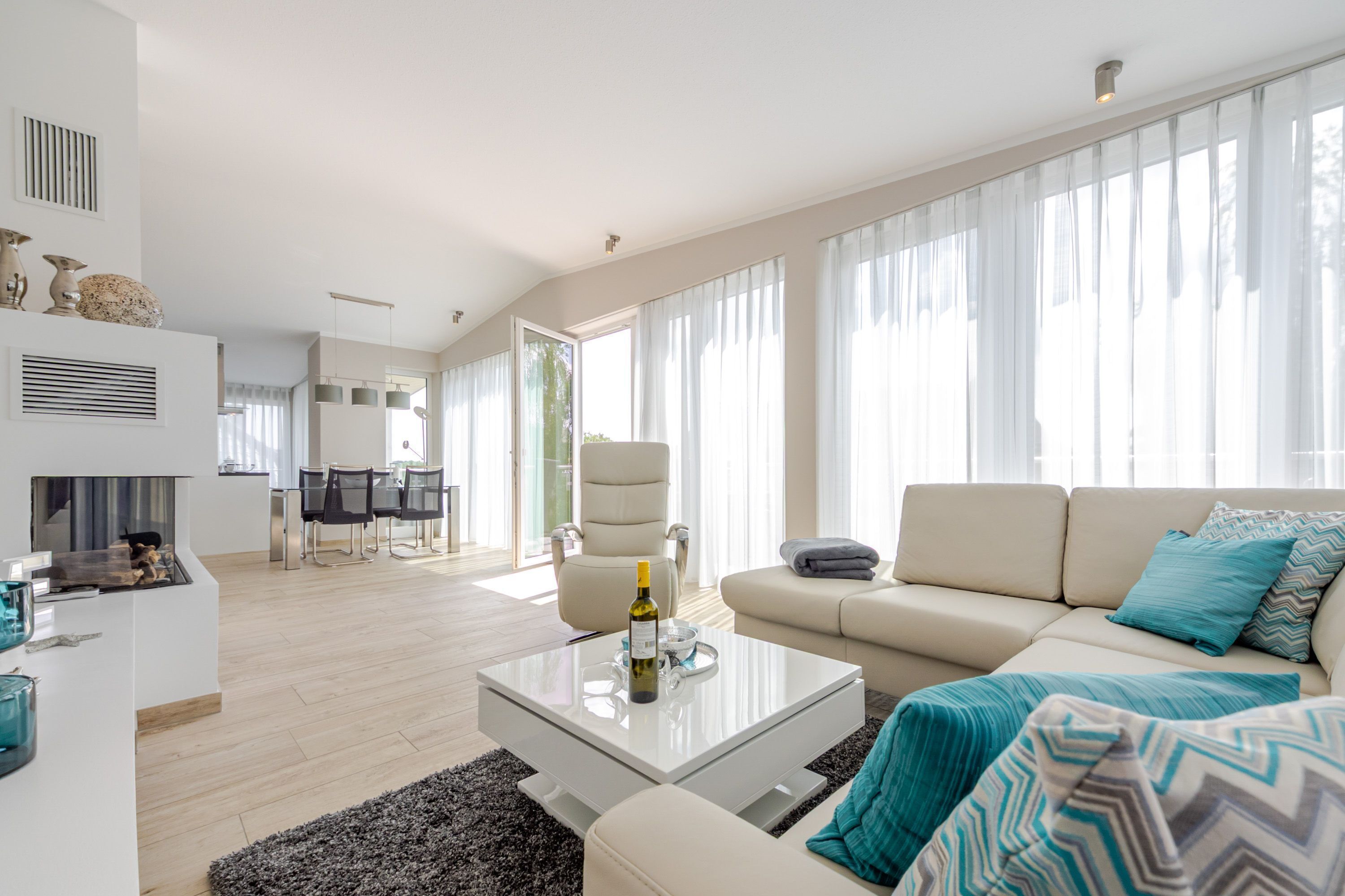 A modern living room with a sofa, coffee table, and dining area.