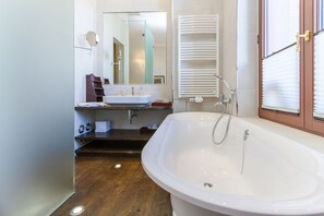 A modern bathroom with a freestanding bathtub, a sink, and a mirror. - Villa Hintze, App. 06 (Heringsdorf)