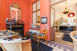 Quarto com lareira, espelho, mesa de jantar e uma cadeira.