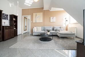 Ein modernes Wohnzimmer mit einer Eckcouch, einem Couchtisch und einer dunklen Holzkommode.