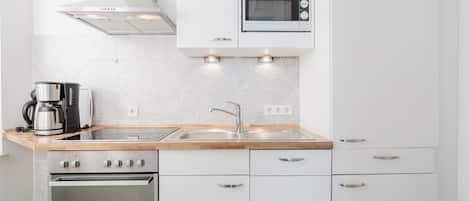 Een koffiezetapparaat/waterkoker, een koelkast, een magnetron, een oven
