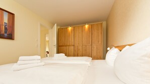 Una camera d'albergo con un letto grande, un armadio in legno e un quadro appeso al muro.