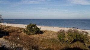 A beach with a clear view of the sea, a sandy path, and some vegetation. - Beach residences Bansin, Ostseepalais 08 (Heringsdorf)