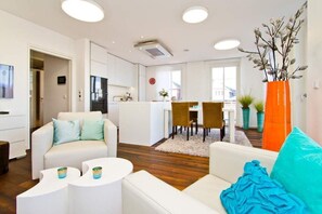 Un salon moderne comprenant un canapé, une table basse et un coin repas avec des chaises et une table.
