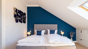 A modern bedroom with a large bed, two bedside tables, and a skylight. - Villa Linquenda, App. 6 (Heringsdorf)