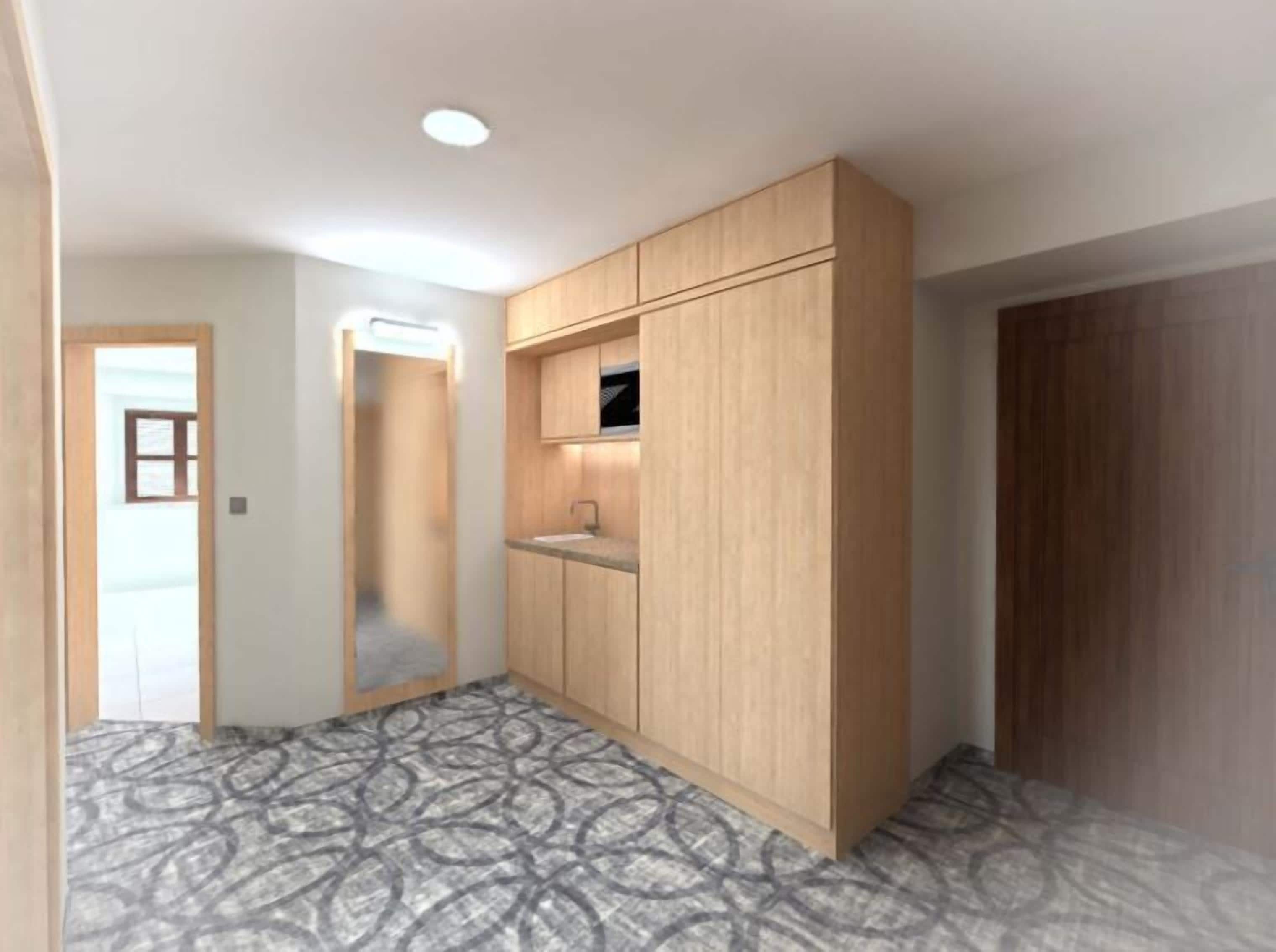 Ein Zimmer mit integriertem Kleiderschrank, einem kleinen Waschbecken und einem Musterfußboden.