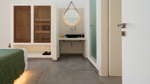 A modern bathroom with a round mirror, a sink, and a toilet. - Citrus Seaside Houses (Naxos)