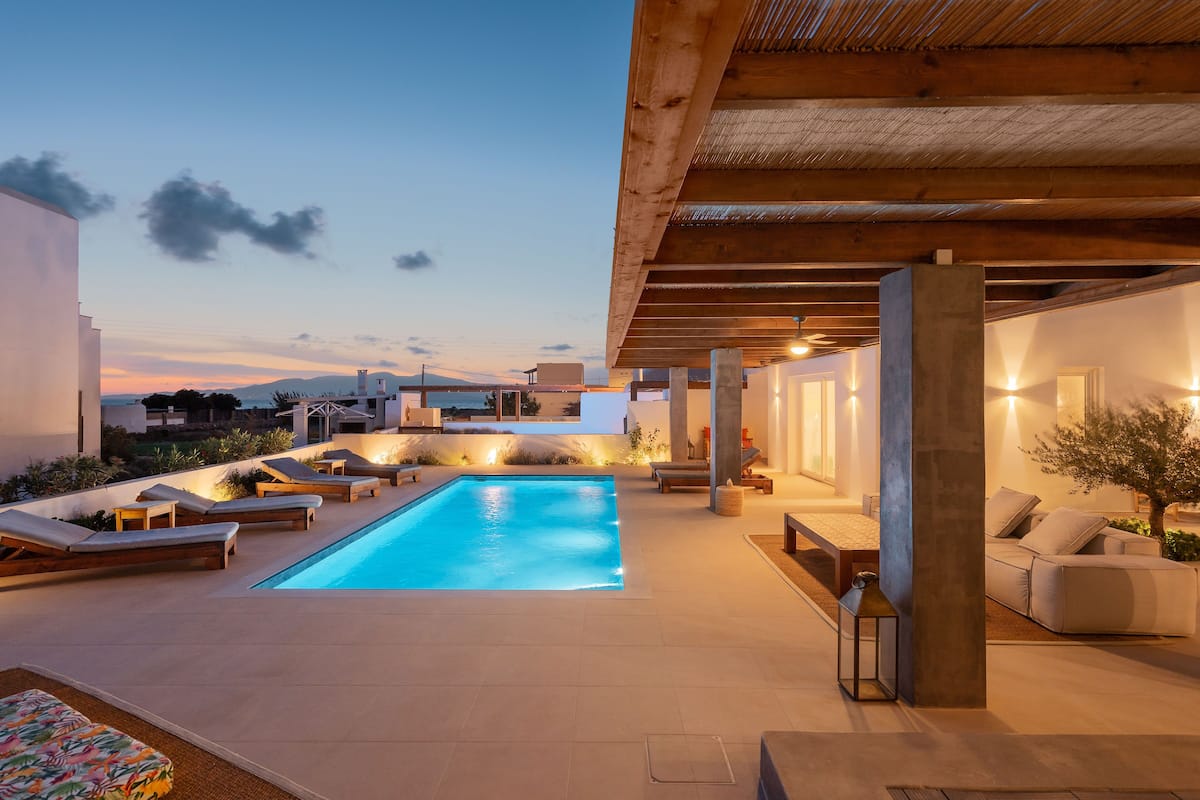 A modern outdoor pool area with lounge chairs and a wooden pergola.