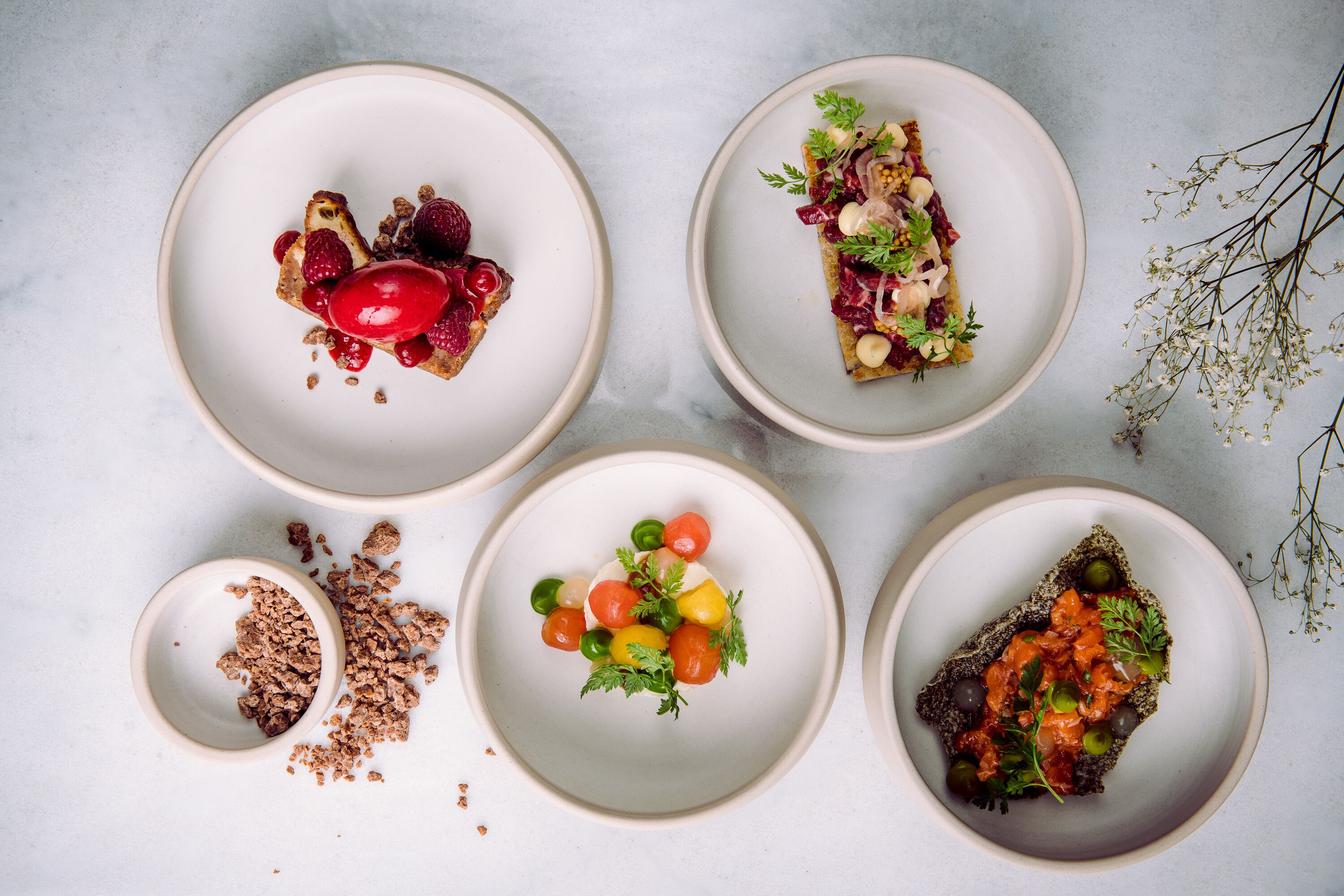 Cinco platos de comida sobre una superficie de mármol.