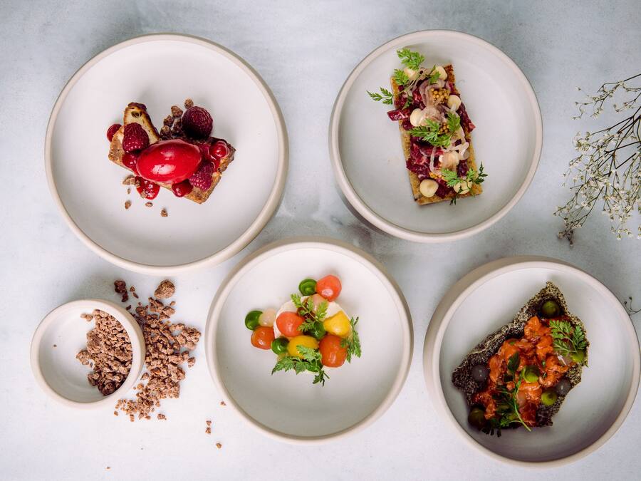 Cinco platos de comida sobre una superficie de mármol.