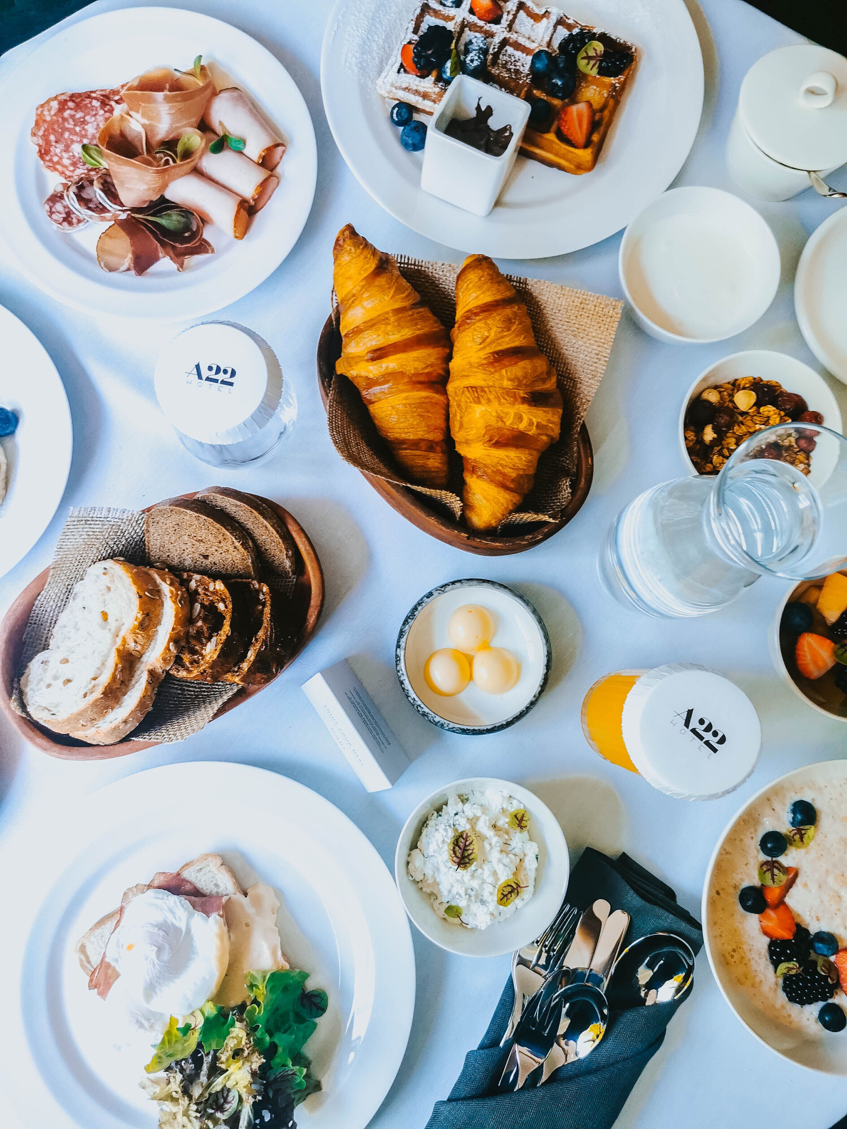 Una mesa dispuesta con diferentes productos para el desayuno, como bollería, pan y diversas mermeladas.