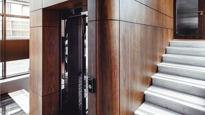 Een modern interieur met een houten wand en een marmeren trap.