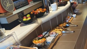 En buffé med ett varierat utbud av mat, inklusive kött, ostar, frukt och tillbehör.