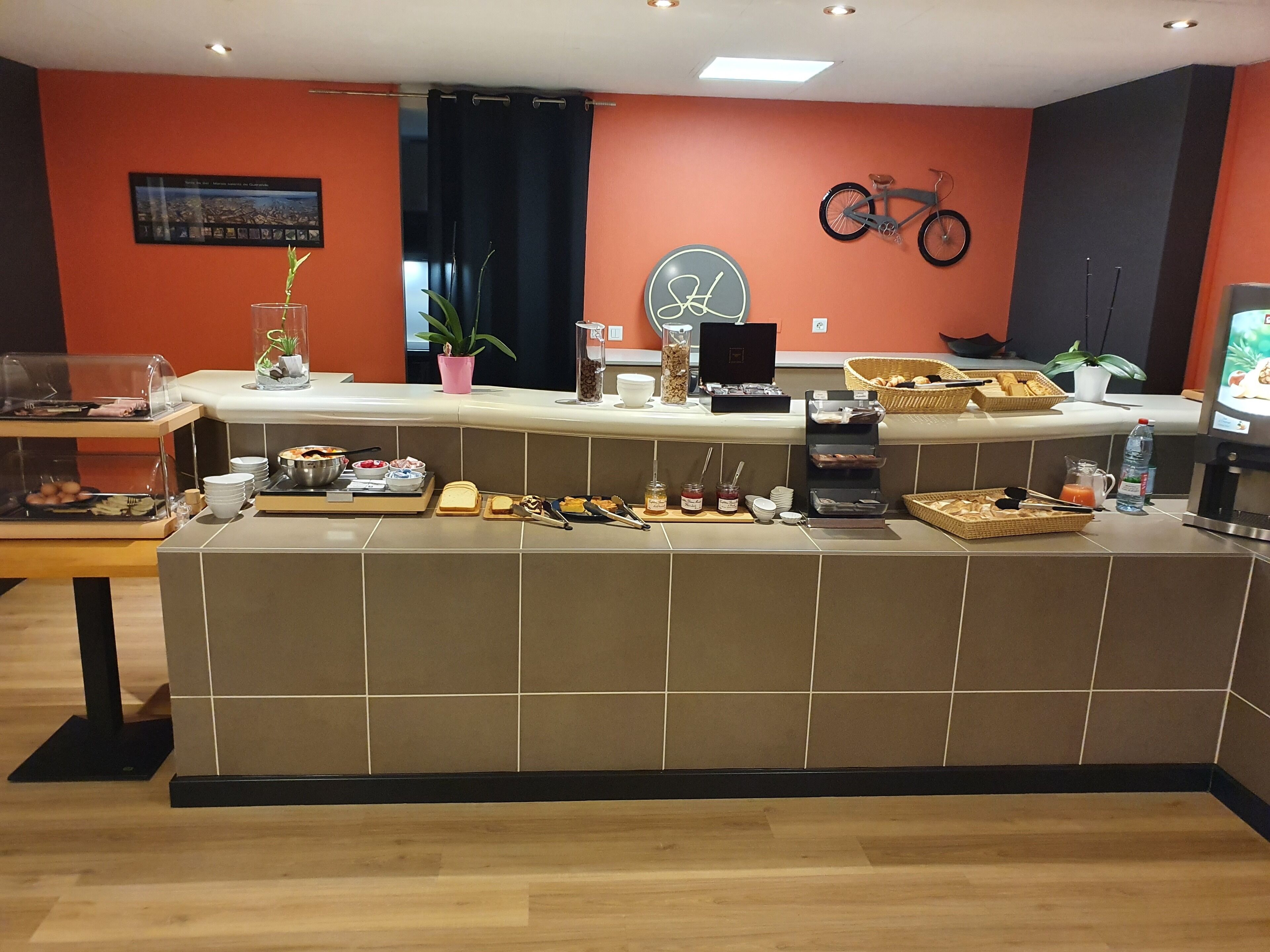 En frukostbar med ett urval av olika matvaror och en cykel som hänger på väggen.