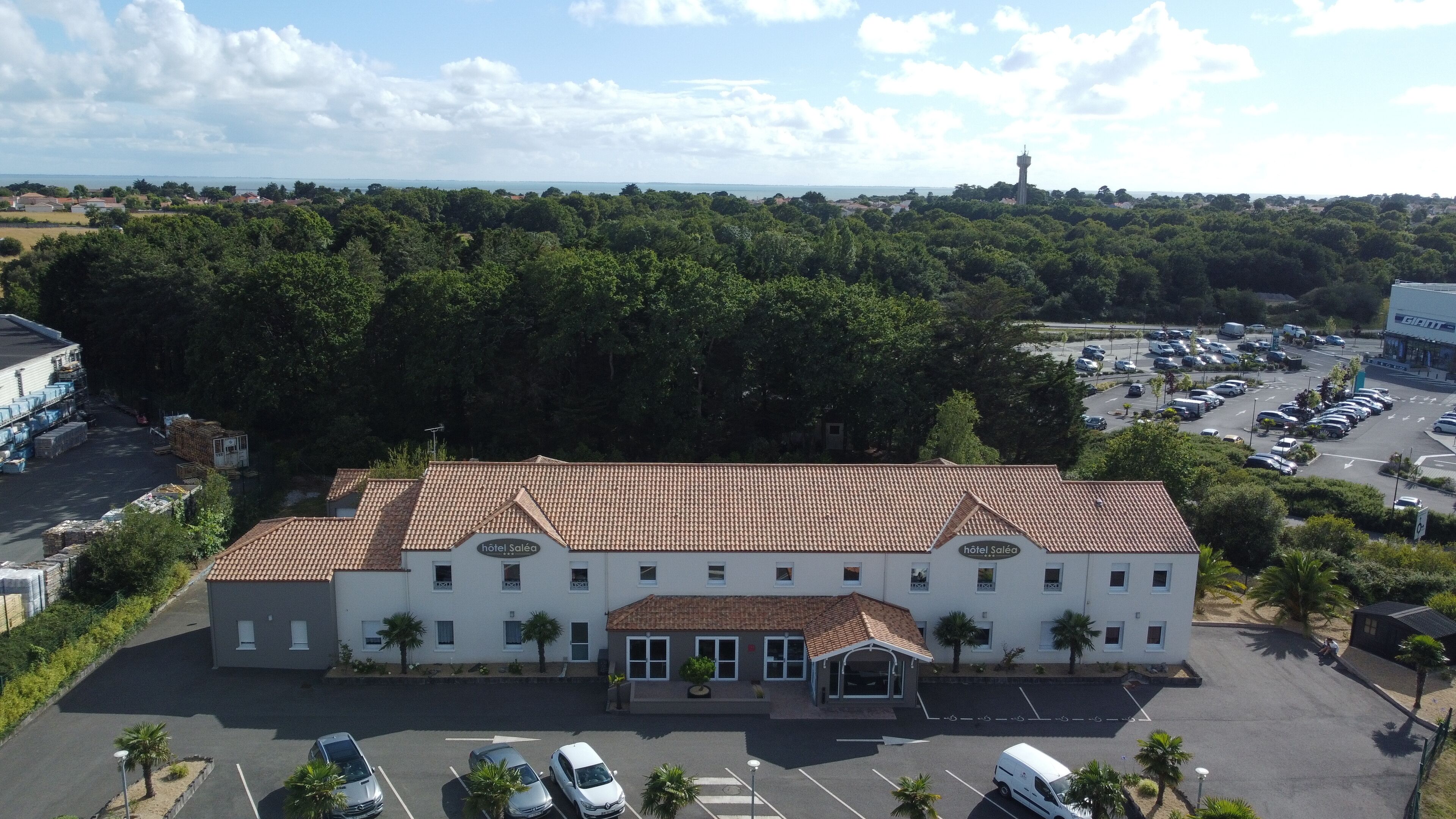 Un hotel con tetto in tegole, diverse finestre e un parcheggio.