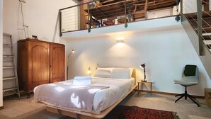 A bedroom with a bed, bedside lamp, chair, wooden wardrobe, and a staircase. - Central New York-Style Loft with parking - Inner City Apartment - Chippendale (Chippendale)