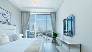 Camera d'albergo moderna con un letto grande, vista sulla città e arredamento minimalista.