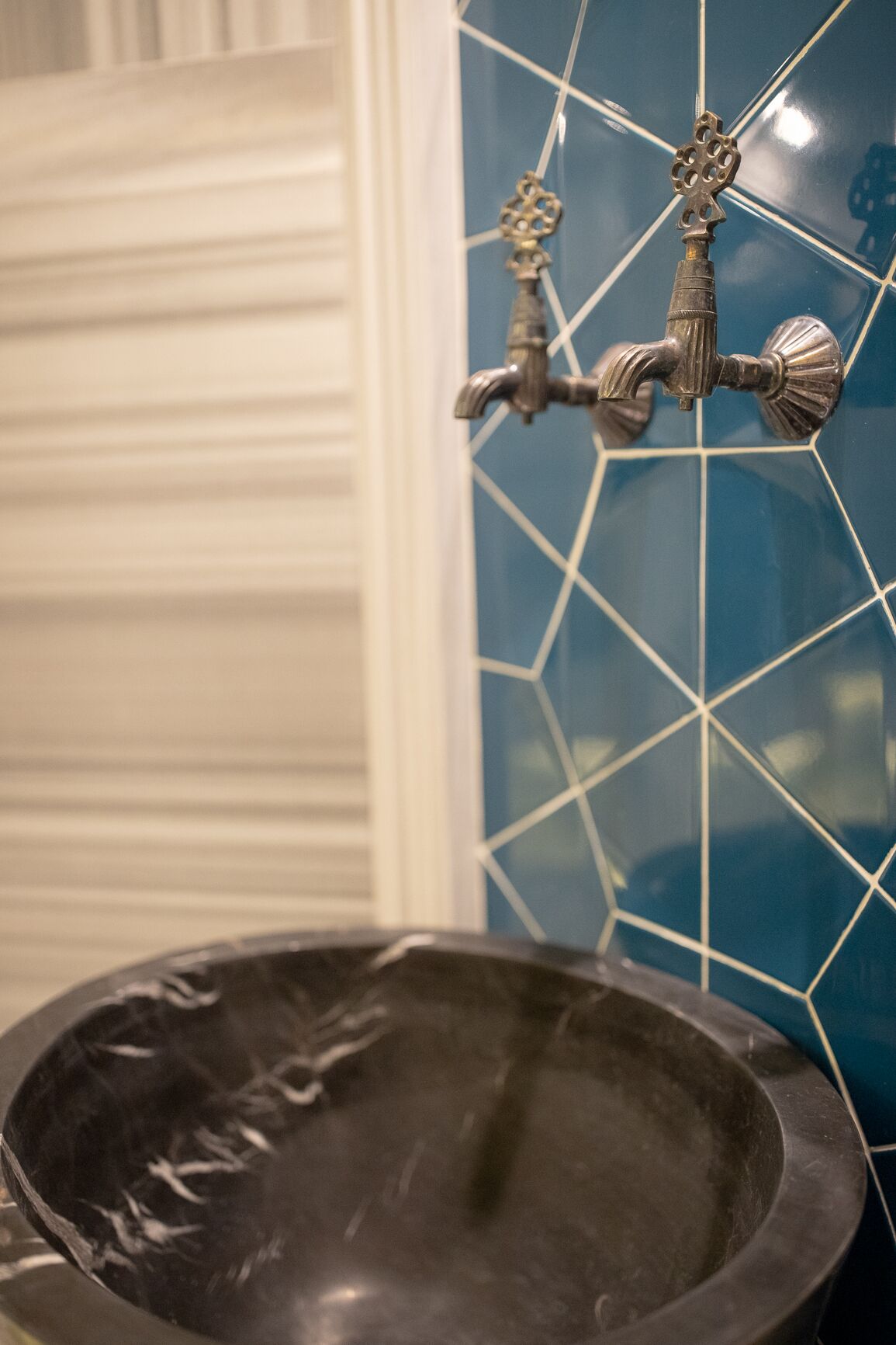 Une salle de bain avec un lavabo noir et un robinet décoratif.