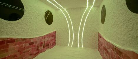 A room with a brick wall, a circular window, and a ceiling with light strips.