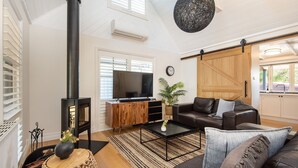 Una sala de estar con chimenea, televisor, sofá y mesa de centro.
