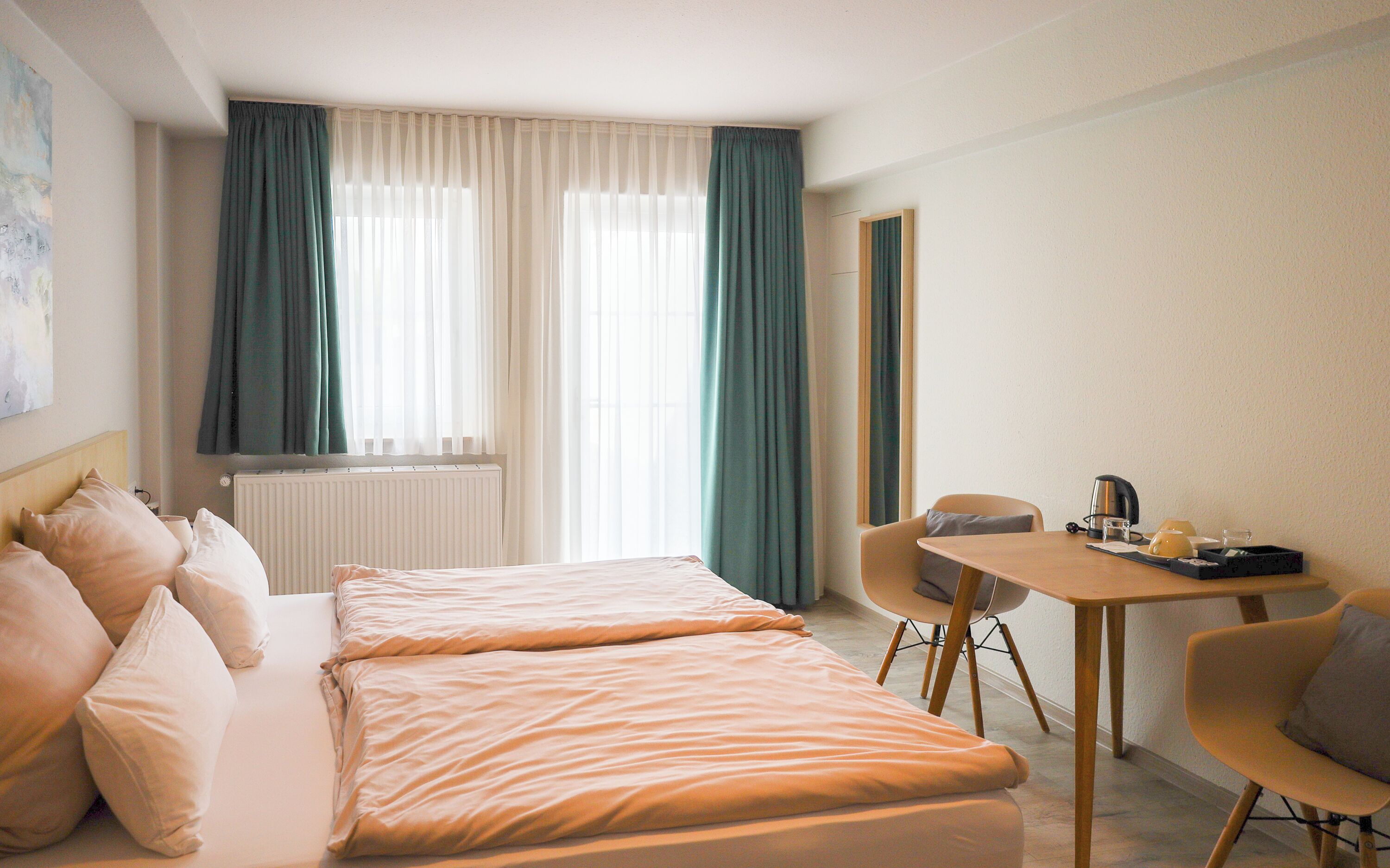Une chambre d’hôtel avec un lit, un bureau et une chaise.