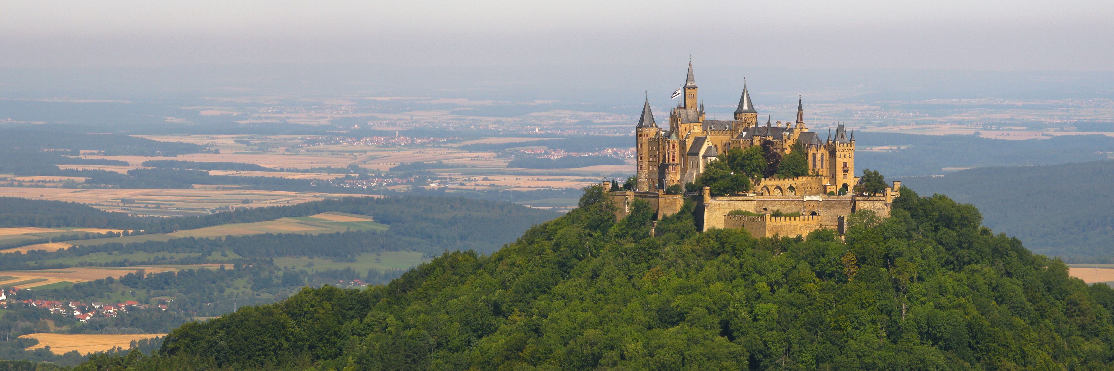 Um castelo no topo de uma colina, com vista para a paisagem ao redor.