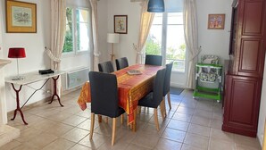 Un coin repas comprenant une table, des chaises, une lampe et un porteur pour bébé.