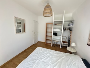 A bedroom with a bed, a wardrobe, a mirror, a hanging light, and a chair. - Spacious Villa Near Beach and Town Center with Large Private Garden (Villers-sur-Mer)