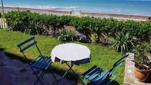 A patio with a table and chairs overlooking the ocean. - Cabourg: Modern 4/5-room apartment, beach access, 8 ppl, garden and terrace, parking, WIFI (Cabourg)
