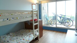 A bunk bed room with a window and bicycles outside. - Cabourg: Modern 4/5-room apartment, beach access, 8 ppl, garden and terrace, parking, WIFI (Cabourg)