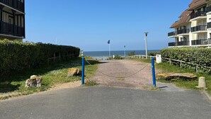 Ein Weg, der zu einem Strand mit freiem Blick auf das Meer führt.