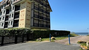 Ein mehrstöckiges Gebäude mit einer Mischung aus moderner und traditioneller Architektur, mit Balkonen und einem markanten Eingangstor.