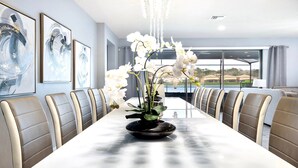 A long dining table with a centerpiece of white orchids, surrounded by leather chairs. - Lakeview ~ Pool Moana Themed Escape w Game Room (Kissimmee)
