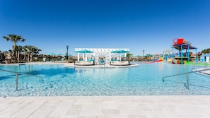 Une piscine aux eaux cristallines, dotée de chaises longues, d’un espace de jeux aquatiques et d’un coin salon abrité.