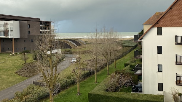 Un quartier résidentiel avec une route, un pont et une vue sur la mer.