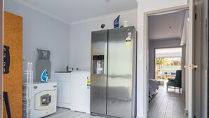 Une cuisine moderne équipée d’un réfrigérateur en acier inoxydable, d’un four encastré et d’un four à micro-ondes.