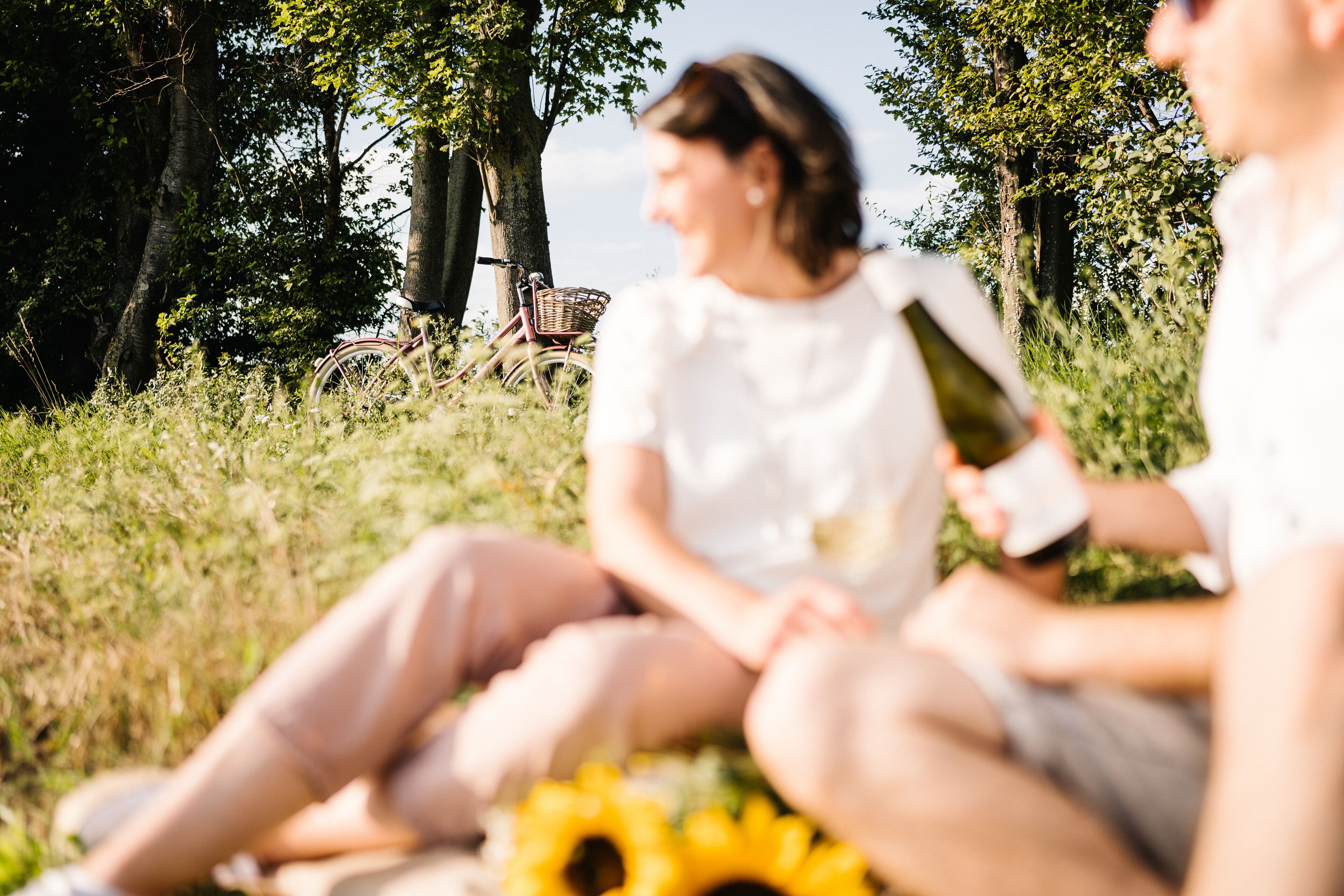 A person sitting on grass with a bicycle in the background.