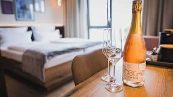 Une bouteille de Becker Pinot Noir Rosé sur une table en bois, avec deux verres à vin vides.